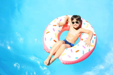 Sevimli küçük çocuk yüzme havuzunda şişme çörek ile