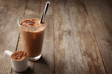 Protein içeceği ve tozu kaşık ile cam 