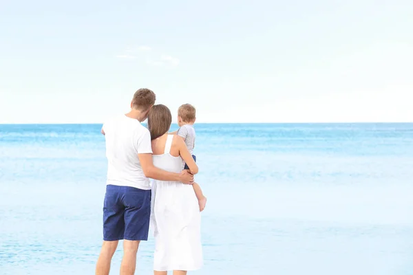 Šťastný pár s malým synem na pláži — Stock fotografie