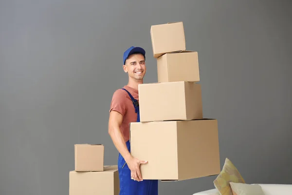 Entrega hombre sosteniendo cajas, en el interior — Foto de Stock