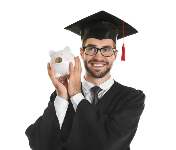 Young graduate with piggy bank on white background — Stock Photo, Image