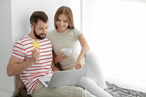 Νεαρό ζευγάρι με φορητό υπολογιστή στο σπίτι. Έννοια αγορών στο διαδίκτυο — Φωτογραφία Αρχείου