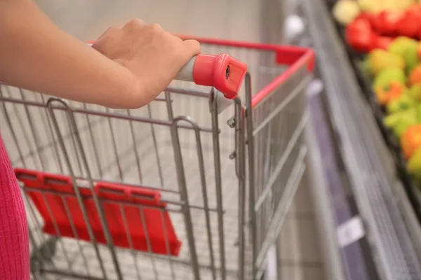 Mujer joven con carrito de compras en el supermercado —  Fotos de Stock