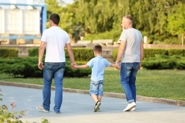 Kleiner Junge mit Papa und Opa spazieren im Park — Stockfoto
