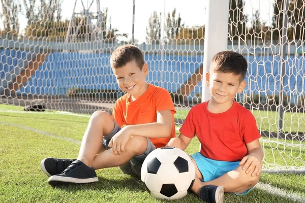 Schattige kinderen met voetbal op veld — Stockfoto