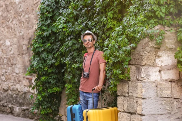 Młody człowiek z walizkami na ulicy — Zdjęcie stockowe