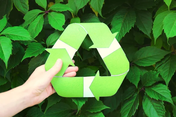 Mulher segurando símbolo de reciclagem ao ar livre — Fotografia de Stock