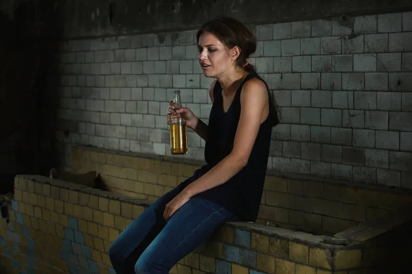 Frau sitzt mit Flasche Alkohol — Stockfoto