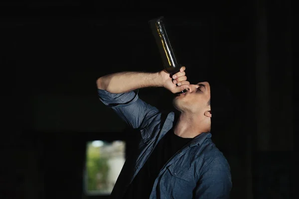 Man drinking alcohol in abandoned building — Stock Photo, Image