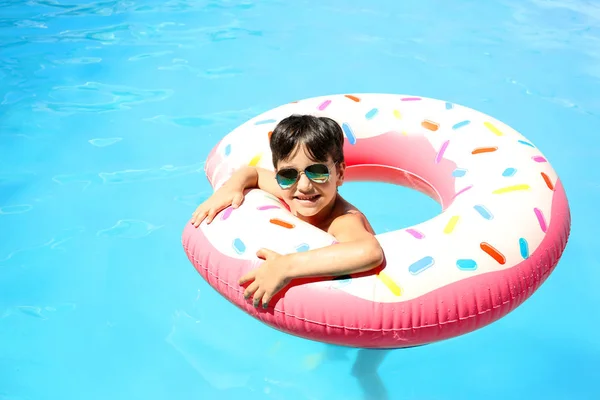 Petit garçon mignon avec beignet gonflable dans la piscine — Photo