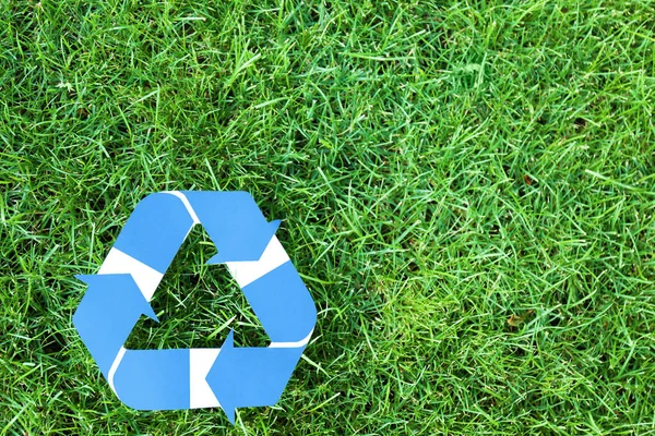 Símbolo de reciclagem na grama verde — Fotografia de Stock