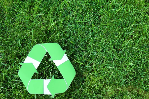 Symbol of recycling on green grass — Stock Photo, Image