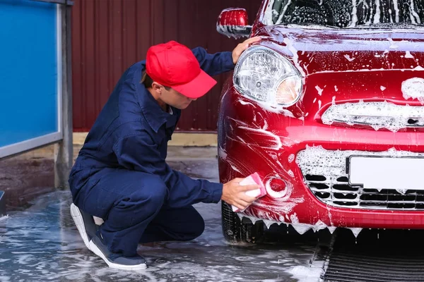 Hombre de limpieza de automóviles con esponja en el lavado de coches — Foto de Stock