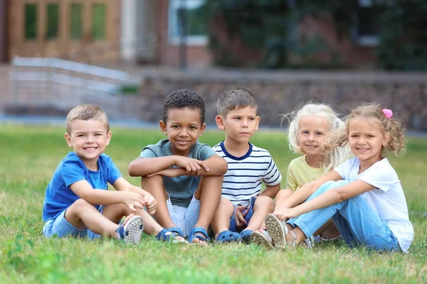 Petits enfants mignons assis sur l'herbe verte — Photo