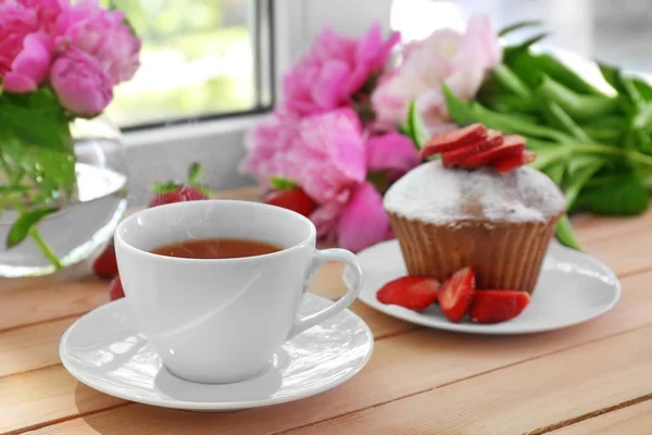 Leckerer Muffin und eine Tasse Tee — Stockfoto