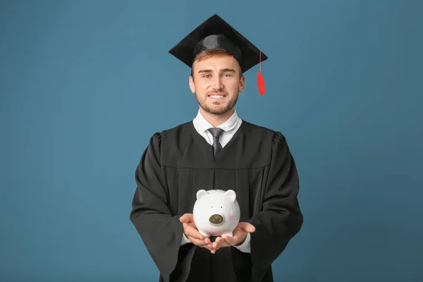 Young graduate with piggy bank — Stock Photo, Image