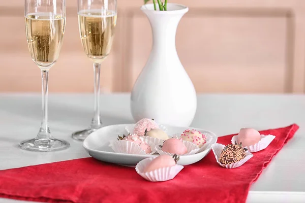 Plaat met smakelijke geglazuurde aardbeien en glazen champagne op tafel — Stockfoto