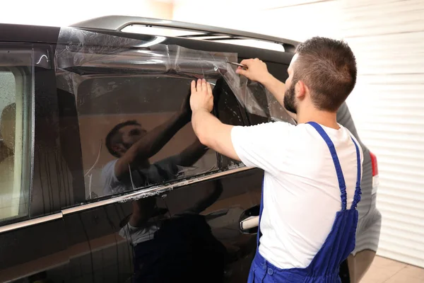 Obrero teñir la ventana del coche en la tienda — Foto de Stock