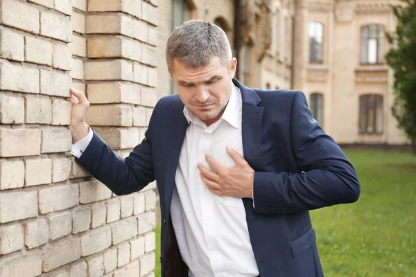 Бізнесмен, який має серцевий напад на відкритому повітрі — стокове фото