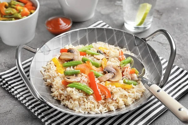 Panela com arroz integral e legumes na mesa — Fotografia de Stock