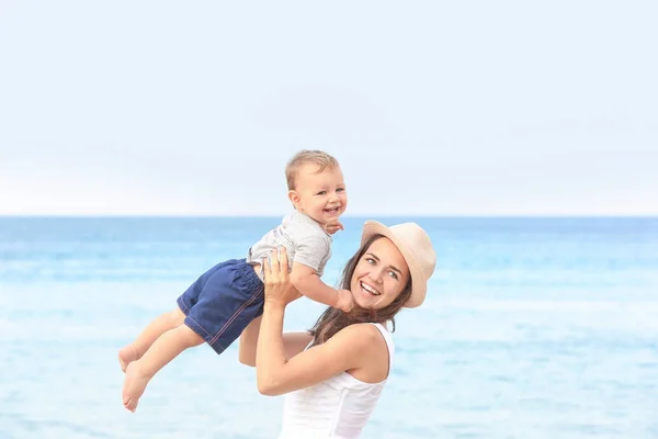 Glückliche Mutter mit kleinem Sohn am Strand — Stockfoto