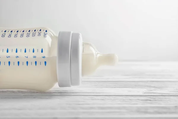 Feeding bottle of baby milk formula on table, close up — Stock Photo, Image