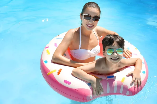 Jeune femme et son fils avec beignet gonflable dans la piscine — Photo