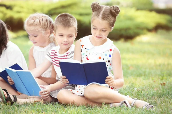 公園で本を読んでかわいい子供たち — ストック写真