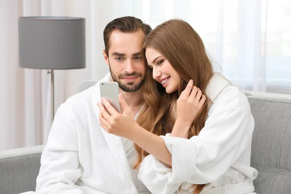年轻爱夫妇穿着浴衣在家采取自拍照 — 图库照片