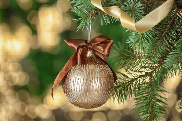 Brunch of fir tree with Christmas ball on blurred background — Stockfoto