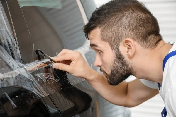 Obrero teñir la ventana del coche en la tienda — Foto de Stock