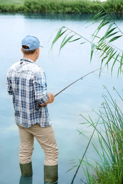 Hombre pescando en la orilla del río — Foto de Stock