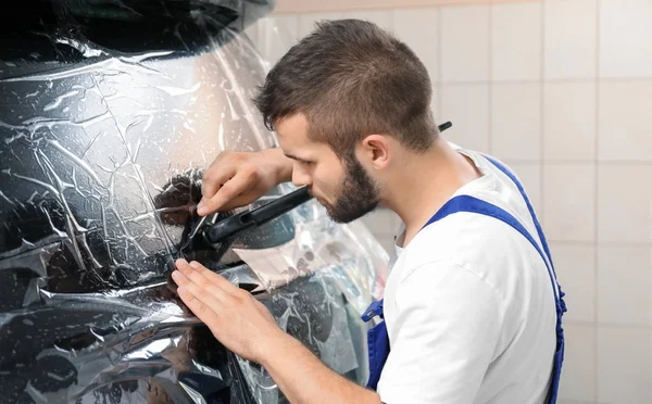 Worker tinting car window in shop — Stock Photo, Image