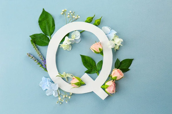 Композиция с буквой Q и красивыми цветами — стоковое фото