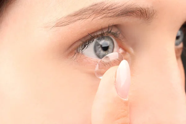 Jonge vrouw zetten contactlens, close-up — Stockfoto