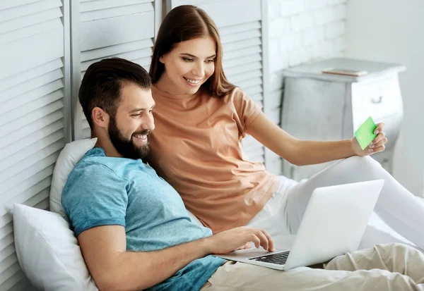 Jeune couple avec ordinateur portable à la maison. Concept de magasinage Internet — Photo