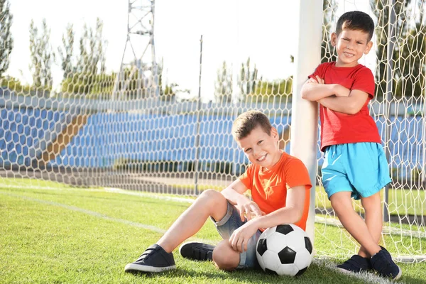 Милые дети с футбольным мячом на поле — стоковое фото