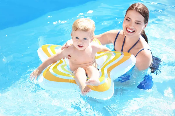 Mor och barn med uppblåsbar ring i poolen — Stockfoto