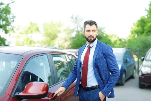 Bonito empresário bem sucedido perto de carro ao ar livre — Fotografia de Stock