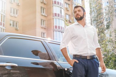 Yakışıklı genç adam araç açık havada yakınındaki beyaz gömlek ayakta