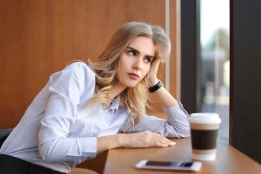 Kafedeki masada oturan genç bir kadın.