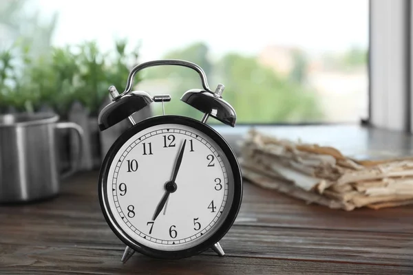 Reloj despertador en alféizar de madera — Foto de Stock