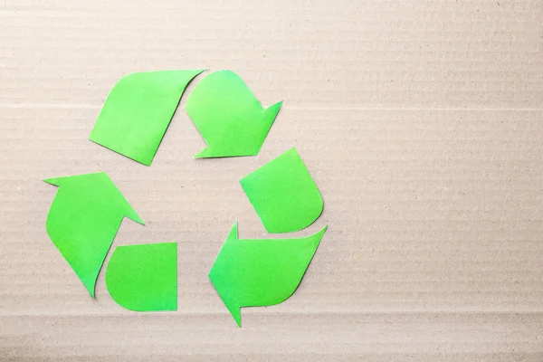 Simbolo di riciclaggio su sfondo di cartone — Foto Stock