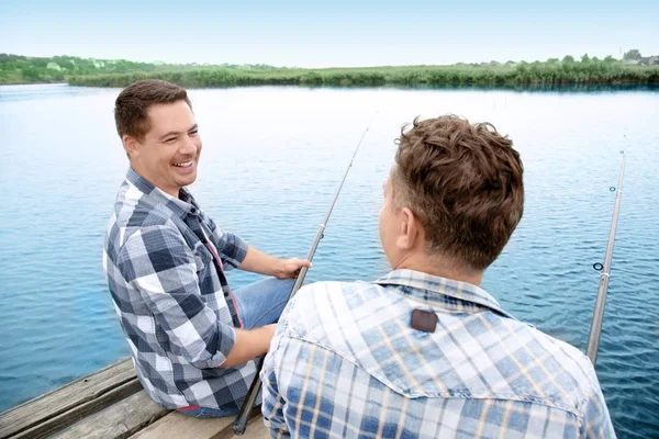 两个男人在河上的码头钓鱼 — 图库照片