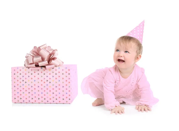 Niedliches Baby-Mädchen in Partymütze mit Geschenkbox auf weißem Hintergrund — Stockfoto