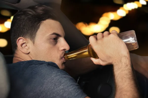 Мужчина пьет алкоголь в машине — стоковое фото