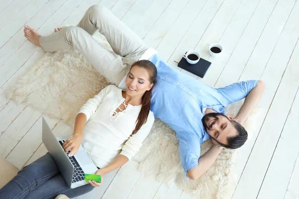 Young couple with laptop and credit card at home. Internet shopping concept