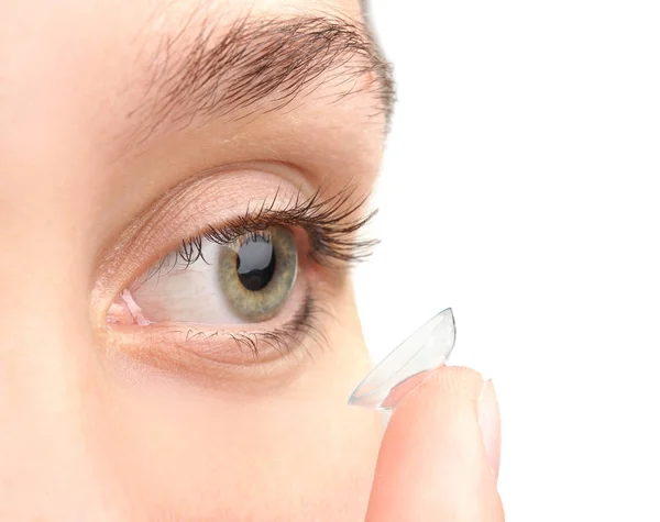 Jonge vrouw contactlens zetten met lichte achtergrond, close-up — Stockfoto