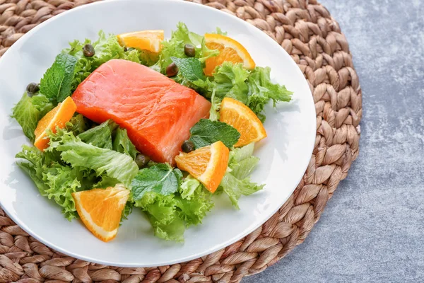 Placa con deliciosa ensalada de salmón en la mesa — Foto de Stock