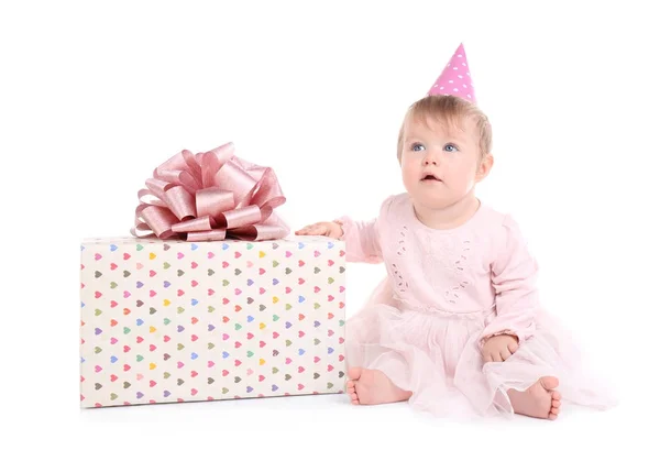 Cute baby girl in party cap with gift box on white background — Stock Photo, Image